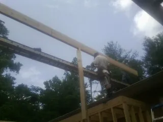 Carpenter setting a ridge beam over a new addition frame — Ice Dam Removal by Roofing Brothers in Waite Park