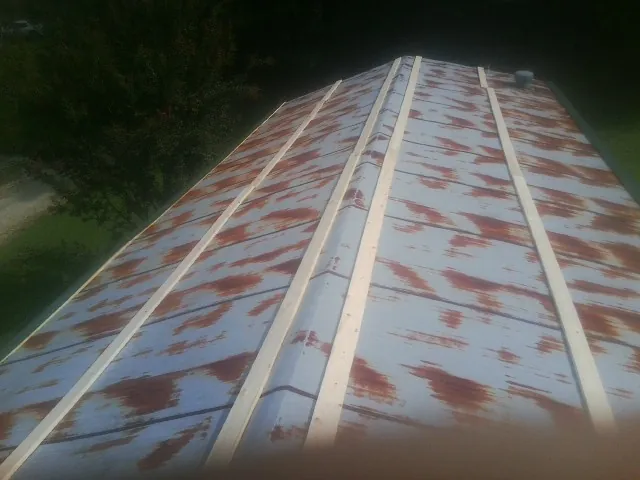 Rusted metal roof panels with new wood purlins before replacement — Storm Damage Roof Repair in Waite Park by Roofing Brothers
