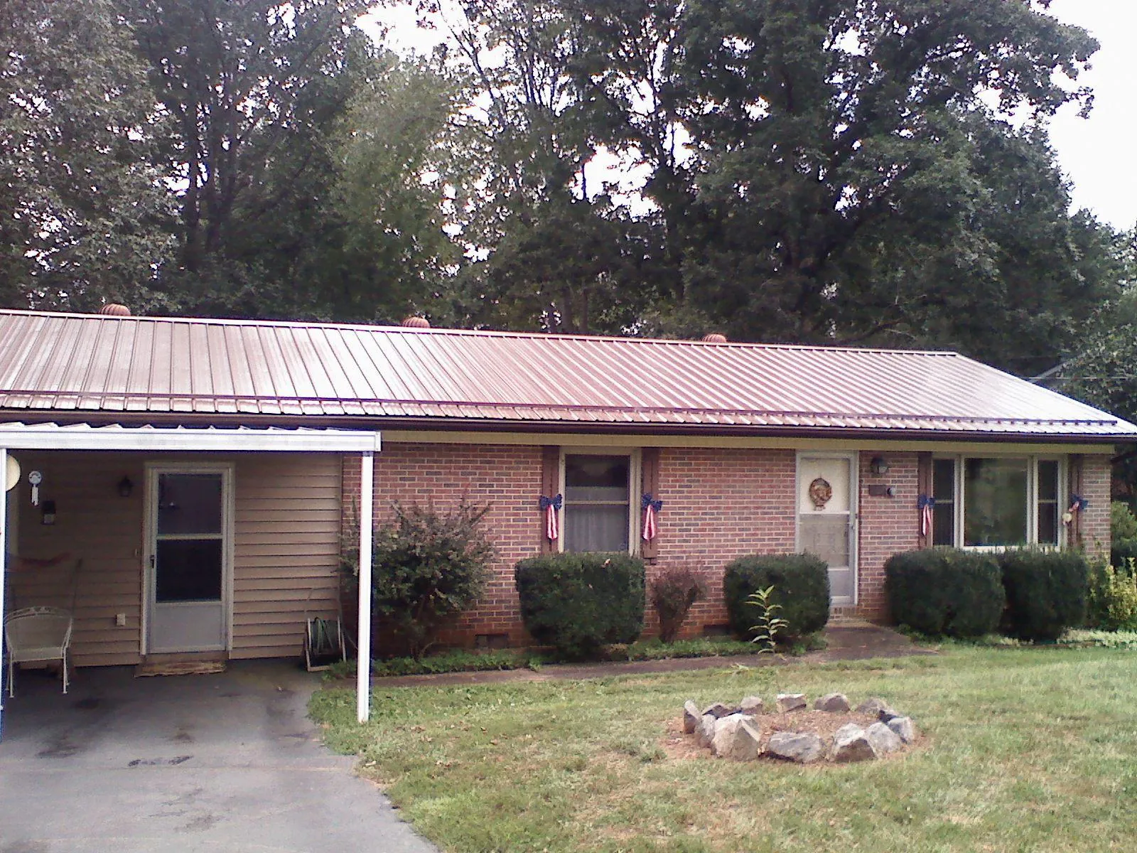 Bronze metal roof and carport on a brick ranch home — Roof Repair work by our crew in Waite Park