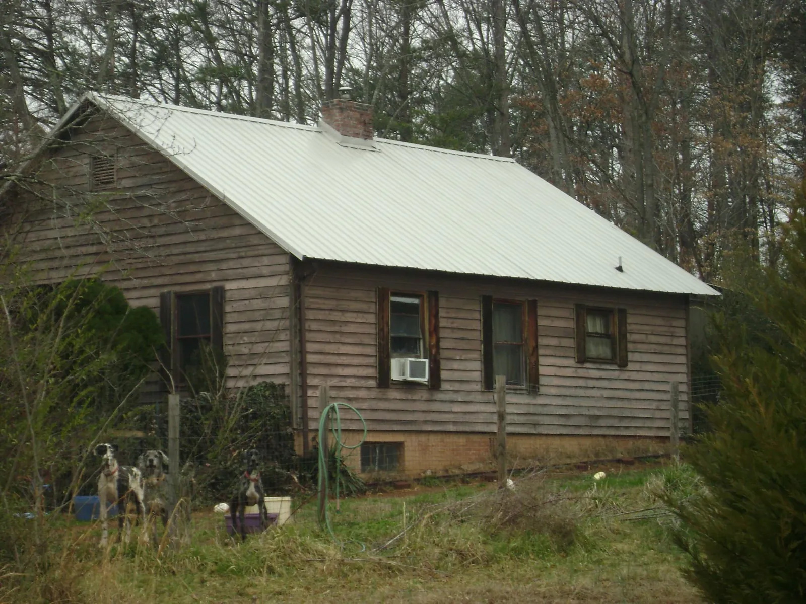 White metal roof on an old wood sided farmhouse, from a Metal Roof Installation job in Waite Park